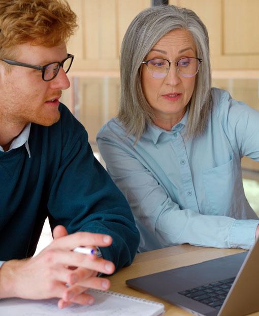 A man and woman looking at data on a laptop