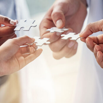 Rare-Disease-Collaborative-Network 4 doctors, each holding a piece of a jigsaw.